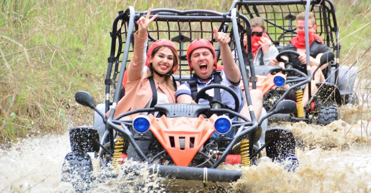 A two-seater UTV buggy splashing through mud on a rugged forest track.