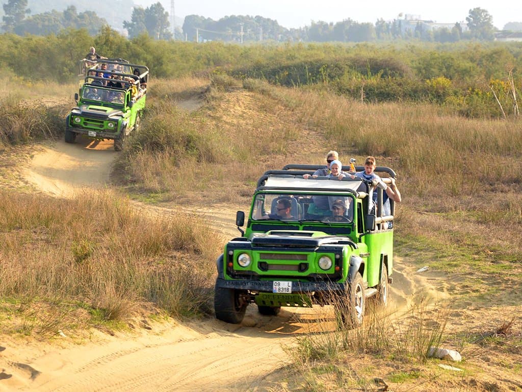 A convoy of off-road jeeps crossing a forest track inside Dilek Peninsula National Park.