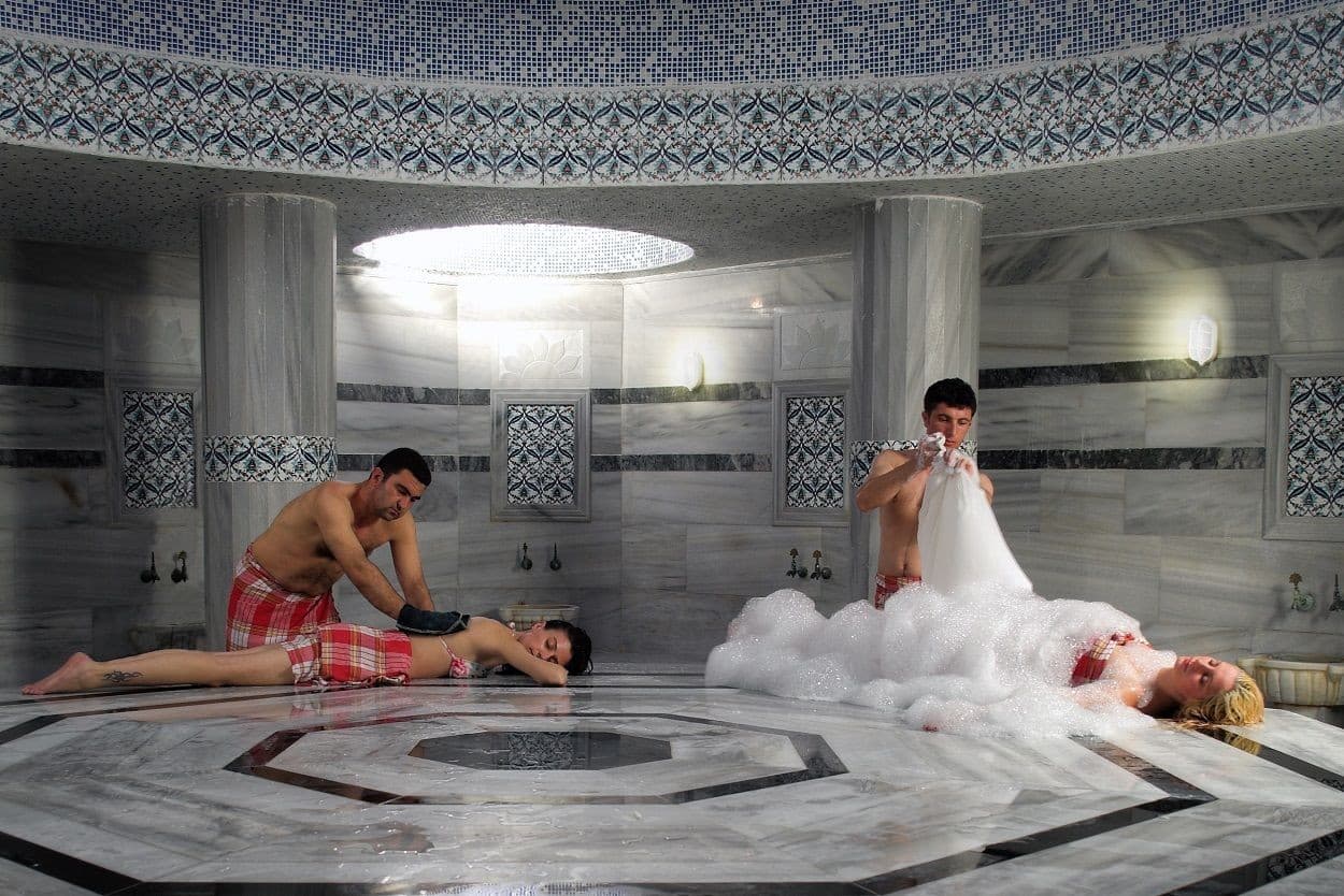 Steam rising over the heated marble göbektaşı of a traditional Turkish hamam.